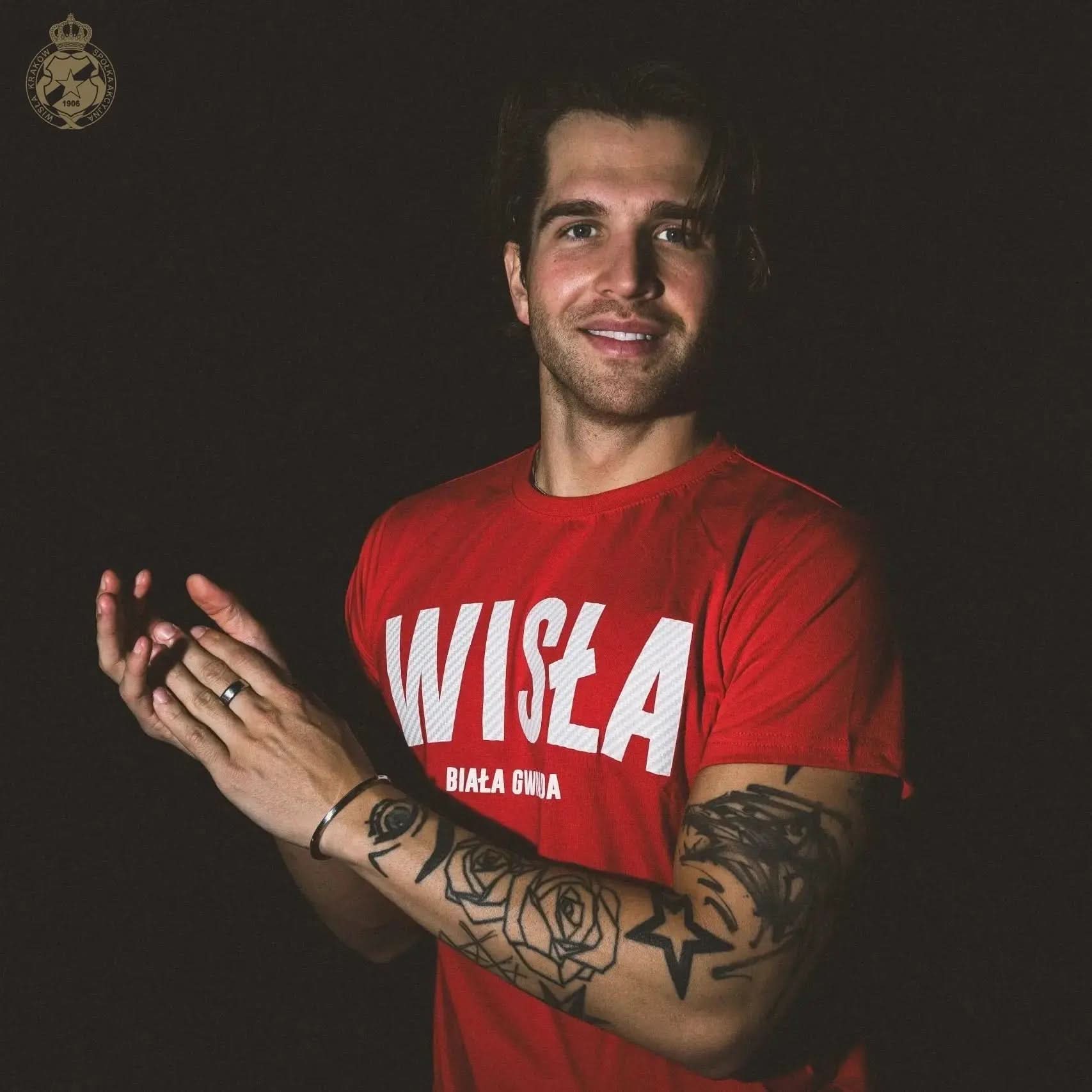 Man wearing a red 'Wisła' t-shirt on a dark background