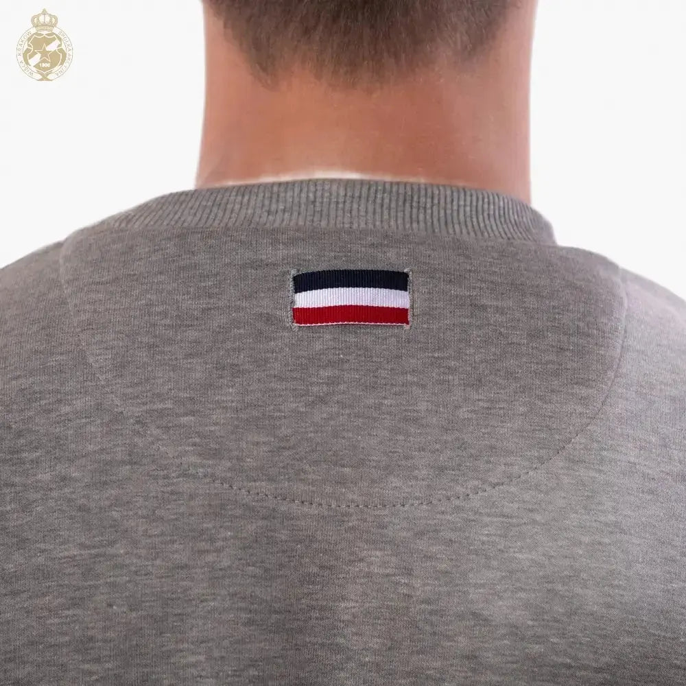 Gray shirt with a flag patch on the back against a white background