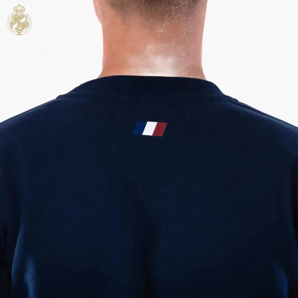 Navy blue sweatshirt with a small flag patch on the back, worn by a person against a white background